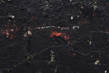 black concrete wall with stains of paint