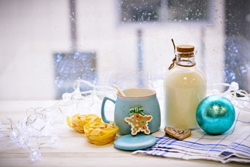 Christmas still-life with an open sugar bowl, white spoon, cookies, pasta, Christmas-tree blue ball, tablecloth in a box on a white wooden table, bright background on a sunny day
