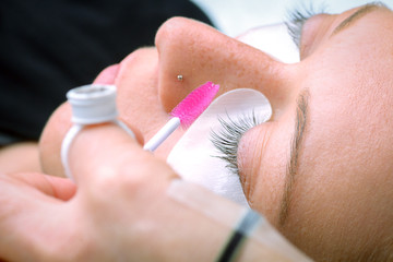 Eyelash extension procedure, woman eye with Long eyelashes