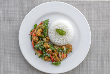 Crispy chicken cooked with sweet basil eat with rice.it is a very delicious Thai food.