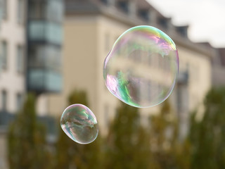 Soap bubbles in front of an old house and trees