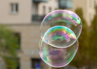 Soap bubbles in front of an old house and trees