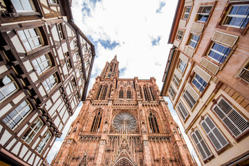Street view from below on the beautiful old buildings and Notre-Dame cathedral in Strasbourg city, France - obrazy, fototapety, plakaty