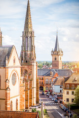 Cityscape view on the old cathedral and tower in Obernai village during the sunny day in Alsace region, France