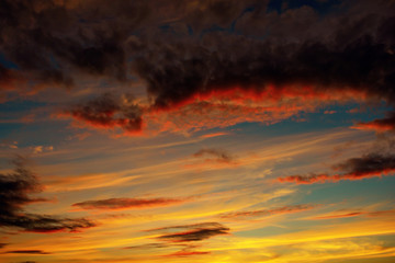 Photo of orange sunset with dark clouds on sky