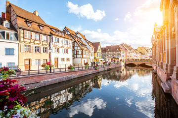 Landscape view on the beautiful colorful buildings on the water channel in the famous tourist town Colmar in Alsace region, France - obrazy, fototapety, plakaty