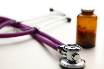 Closeup of a medical stethoscope with folder and bottle of pills