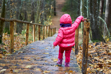 cute funny girl child walks on stairs, summer, cute funny girl child walks on stairs, autumn outdoors, concept childhood. looking down