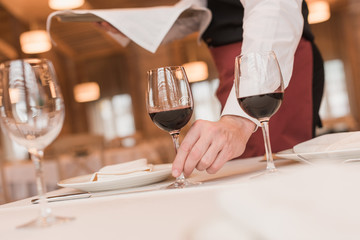 waiter serving wineglasses on table