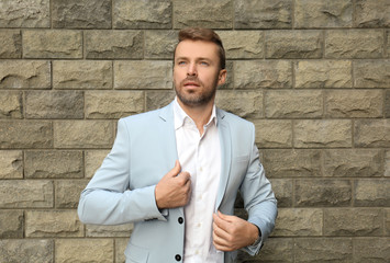 Man in formal suit near brick wall