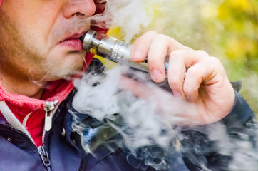 Young man smoking and electronic ciggarette