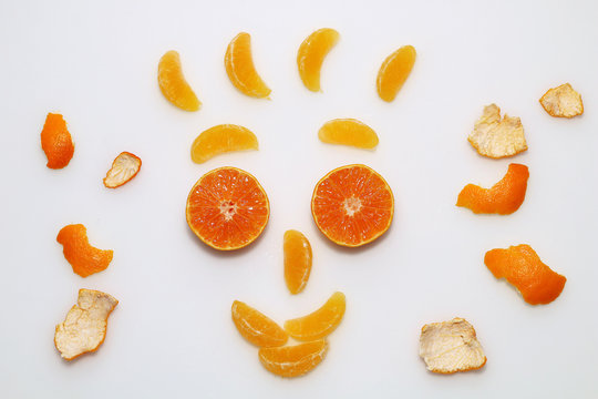 A funny figure in the form of a face gathered from mandarin and tangerine slices