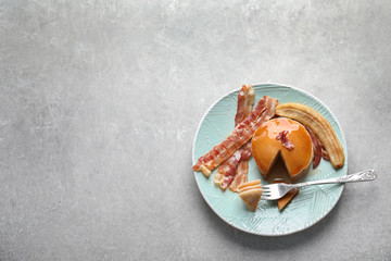 Tasty pancakes with bacon and fried banana on plate