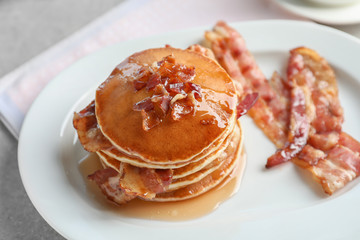 Tasty pancakes with bacon on plate