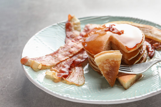 Tasty pancakes with bacon and fried banana on plate