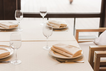 Served table with wineglasses and plates with napkins