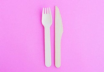 creative wooden recycled fork and knife set on pink background top view pattern
