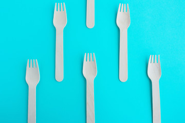 creative wooden recycled fork set on blue mint background top view pattern
