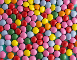 colorful chocolate candy pattern on mint blue background