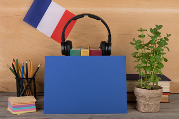 concept of learning French language - blank paper, flag of the France, books, headphones, pencils...