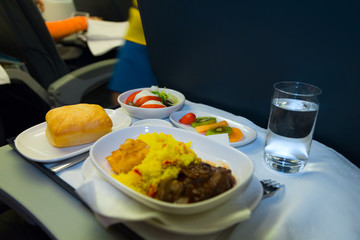 Food served on board of business class airplane on the table. Tray of food in the airplane. Tray of food on the plane, business class travel. Prepared food on the plane