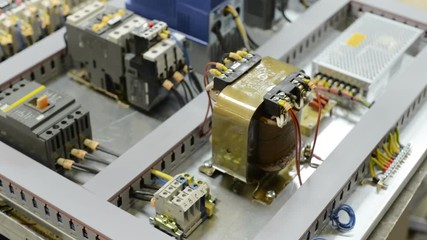 Electrical modules, switches, relays and cables are mounted on the circuit board.