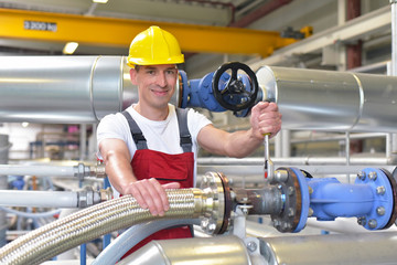 Monteur arbeitet im Rohrleitungsbau in einer Industrieanlage // Engineer works in pipeline...