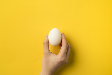 woman holding egg - Powered by Adobe