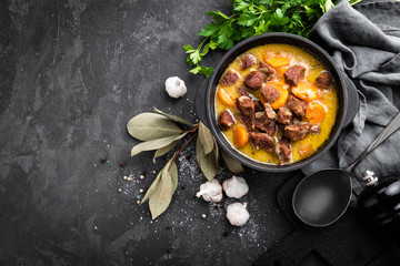 Meat stew, goulash in a cast iron pot, top view - obrazy, fototapety, plakaty