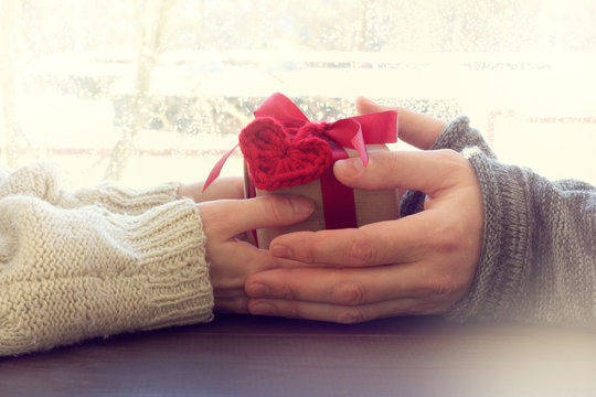 greeting for a loved one/ Transfer gift with heart from hand to hand against the window