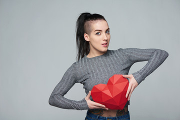 Funky woman holding red polygonal paper heart shape