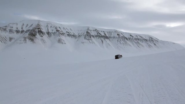 Cross-country vehicle in North Pole Spitsbergen Svalbard Arctic. Way from airport Longyear to Pyramiden on background of glacier.