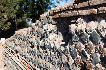Perimeter wall of a house of ancient Rome with the layout of the brickwork that follows the technique of Opus Reticolatum
