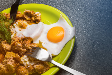 Breakfast - roast beef and fried eggs on a gray  background.