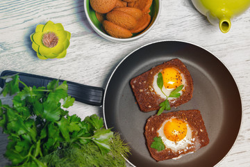 Breakfast -  toast with processed cheese tomato, fried eggs , fried eggs, teapot and cup of tea on a gray  background.