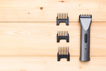 The machine for fashionable haircuts with nozzles on a light wooden background