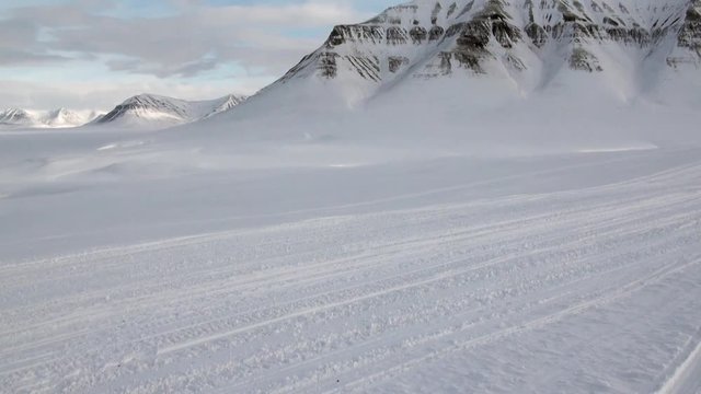 Snowmobile snow bike in North Pole Spitsbergen Svalbard Arctic. Way from airport Longyear to Pyramiden on background of glacier.