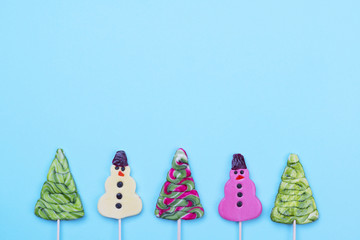 Colorful creative layout forbwinter holidays. Candy lollipops of snowman and Christmas tree.