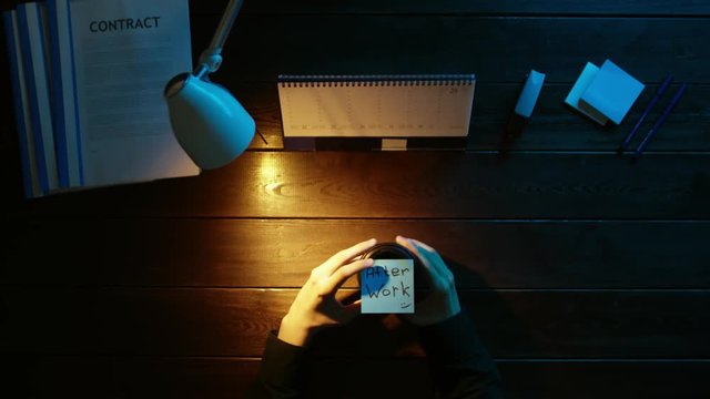 A man is sitting at an office desk and using a phone.