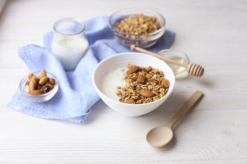 Healthy breakfast. Yogurt with granola and nuts on window sill