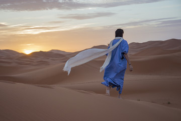 Fototapeta na wymiar Ragazza nel deserto del Sahara, Merzouga, Marocco