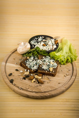 cottage cheese with spirulina powder on two pieces of brown bread
