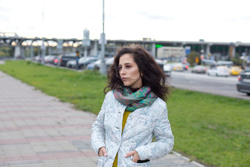 Fototapeta premium Portrait of a beautiful girl in an urban landscape in autumn