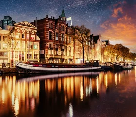 Zelfklevend Fotobehang Beautiful night in Amsterdam. Night illumination of buildings and boats near the water in the canal. © standret