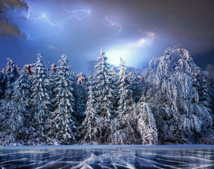magical winter snow covered tree. Dramatic Thunderstorm Sky. The winter lake is frozen on the front