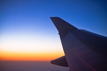 Plakat Air plane engine and wing on the sky with sunrise as background