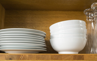white dishes and glasses in a kitchen shelf