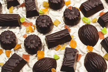 chocolate candies, candied fruits on a light background