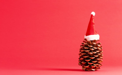 Christmas themed pinecone with santa hat on red