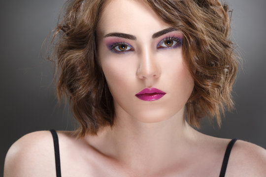 Fashion beauty portrait of a girl with a bright make-up in lilac tones.